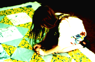 child tying a quilt